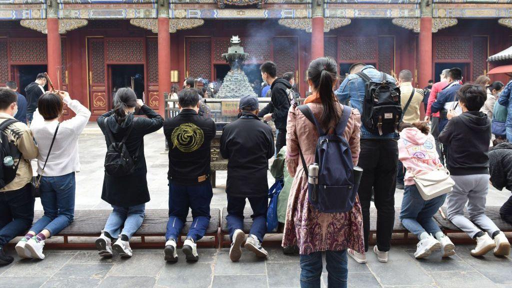 People hold incense as they pray at the Yonghe lamasery. As the largest combination of Han Chinese and Tibetan styles Buddhist temple in Beijing, 