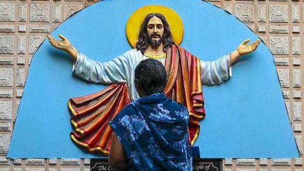 A Christian devotee prays in front of a statue of Jesus Christ during a Good Friday procession in Mumbai on April 3, 2026. (Photo by Indranil MUKHERJEE / AFP via Getty Images)