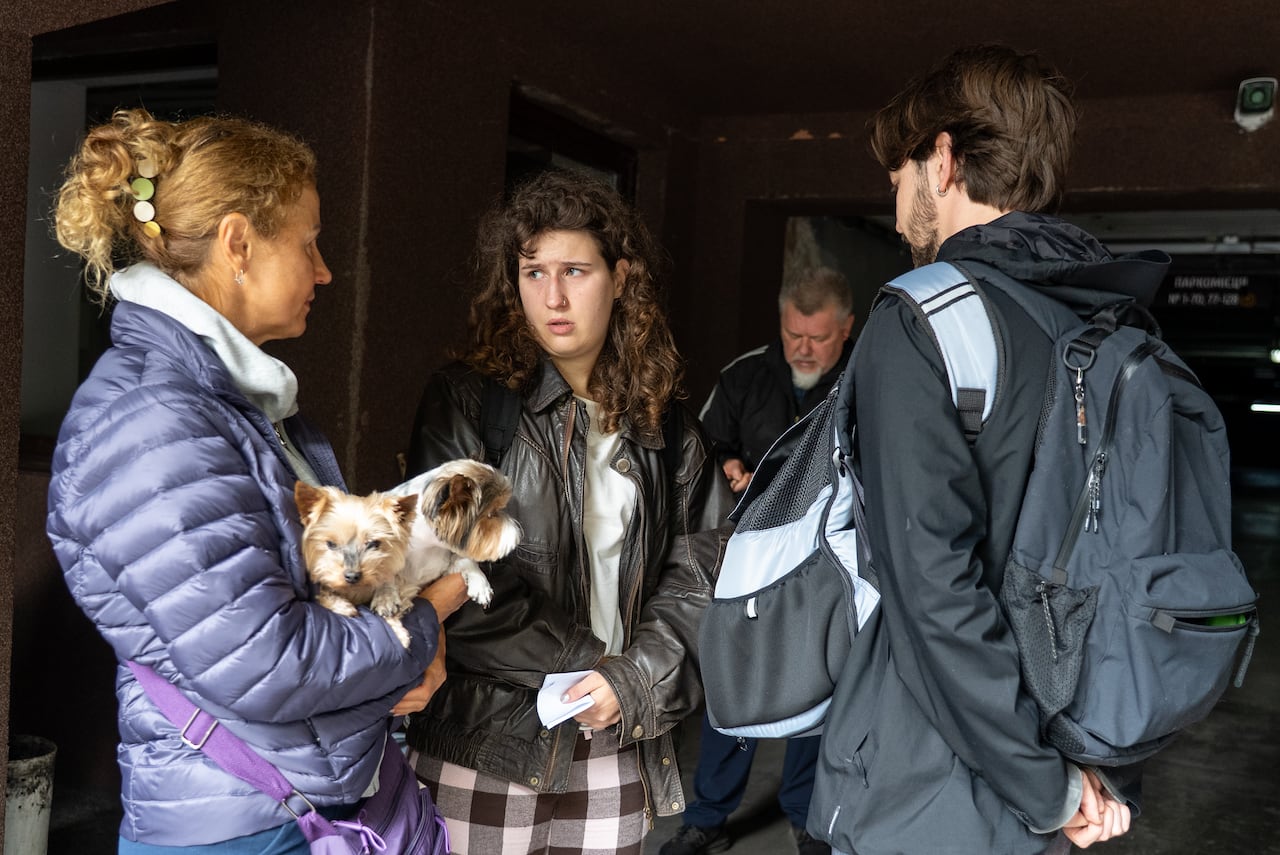 A family stands in a parkade and one woman holds two dogs.