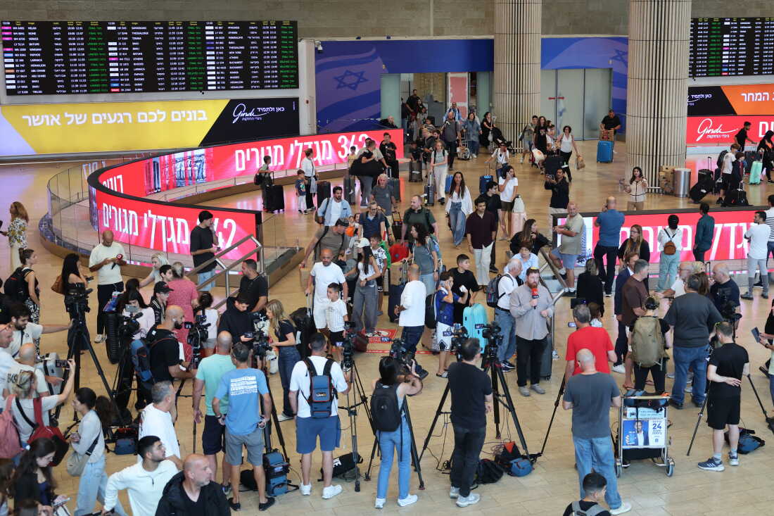 Media representatives gather along with passengers at Ben Gurion Airport near Tel Aviv on Wednesday after a flydubai plane bound for Tel Aviv was forced to land in Saudi Arabia following an "incident," the airline said.