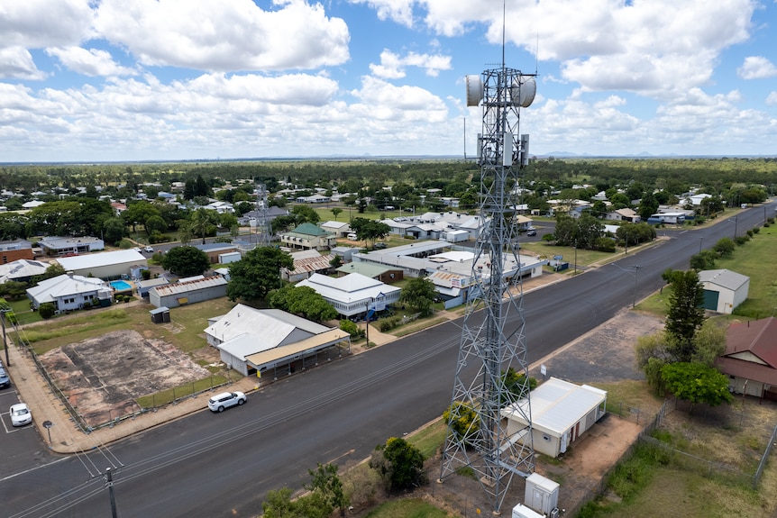 An aerial view of a wide road through a small town.