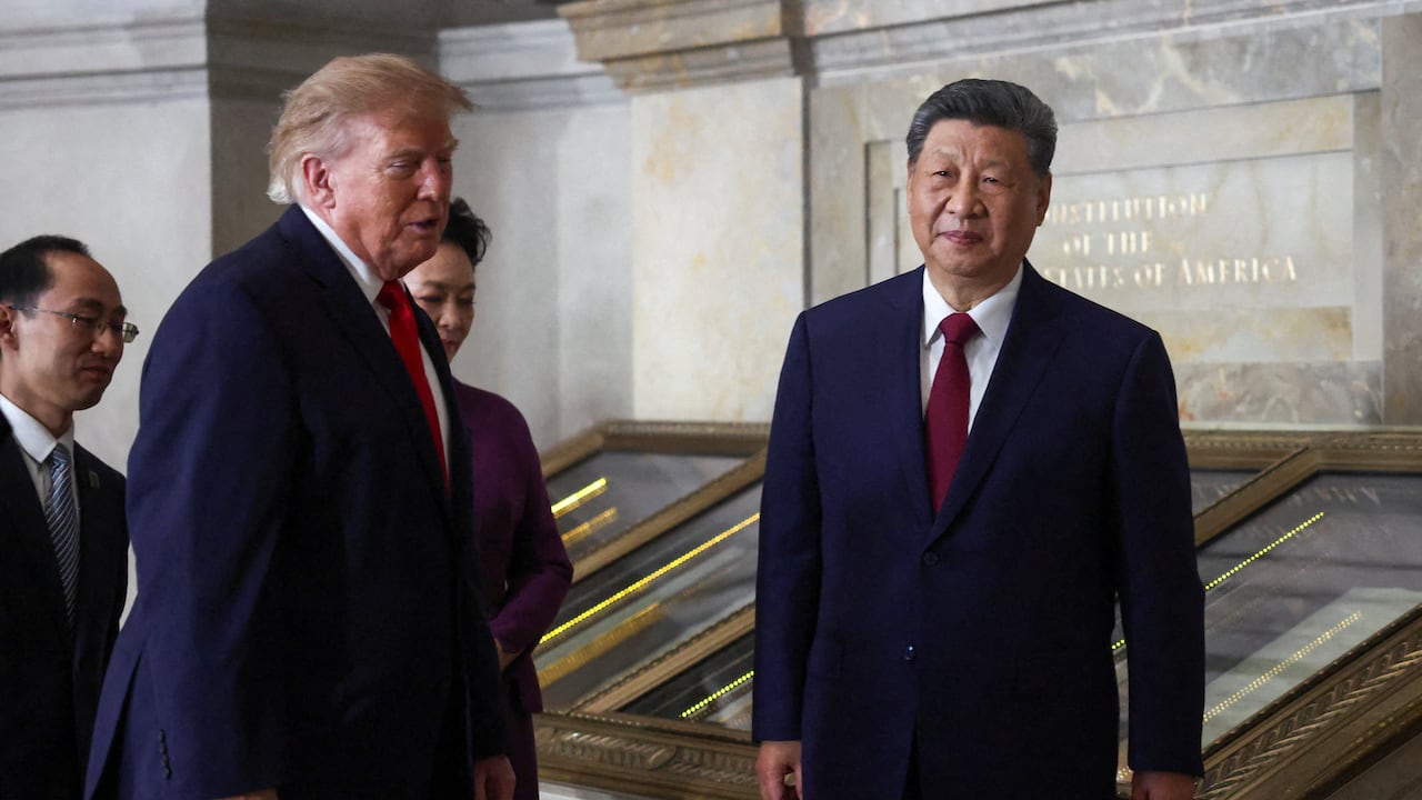 An elderly man in a suit (U.S. Donald Trump) stands with another man (Chinese President Xi JinPing) in a hallway