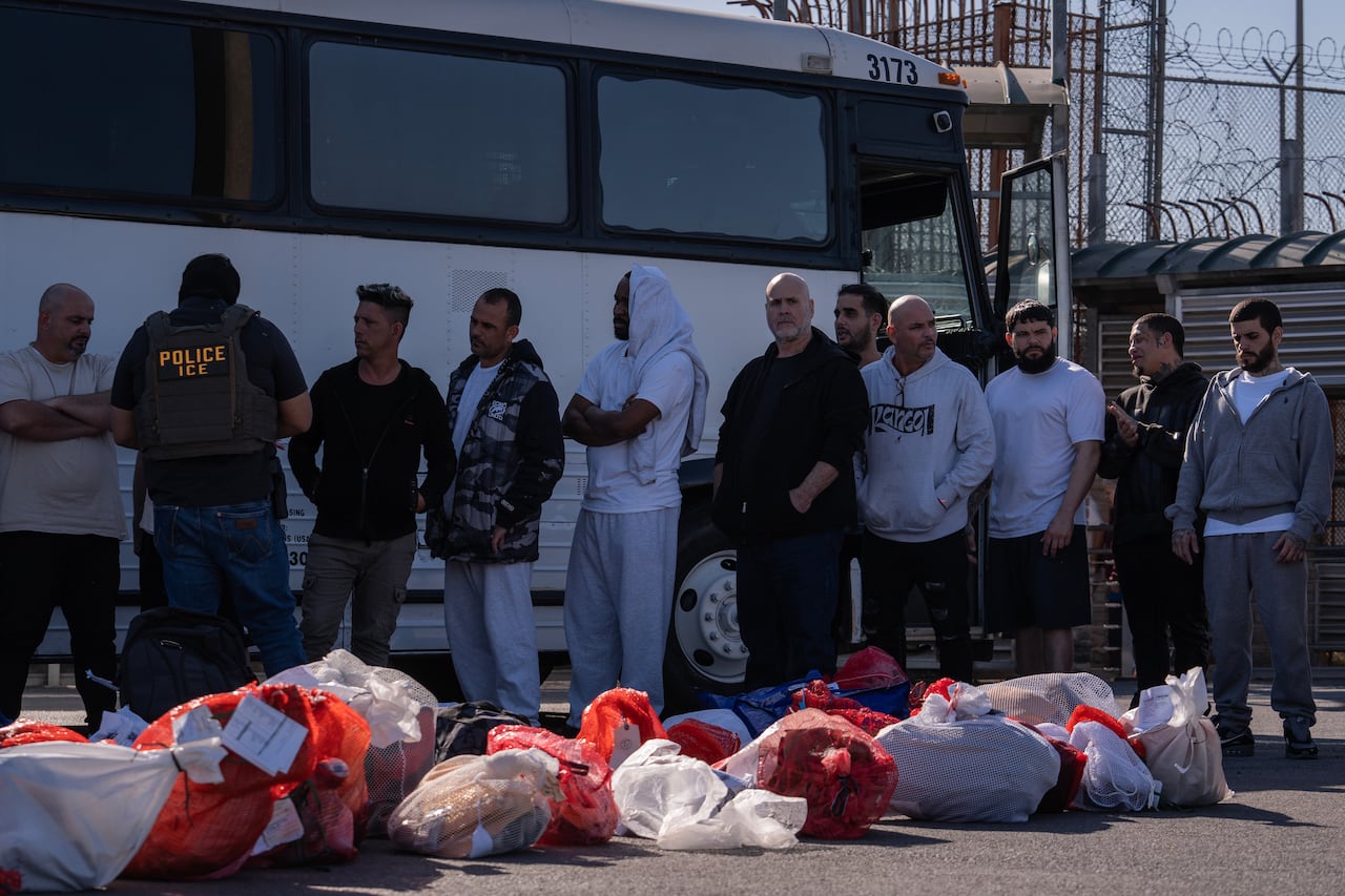 A line up of individuals beside a bus