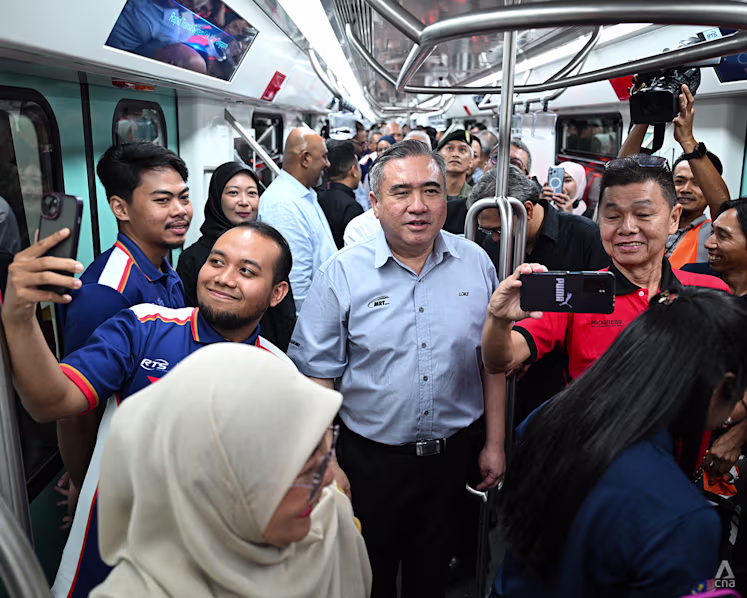 Malaysia’s Transport Minister Anthony Loke meets and greets passengers aboard an RTS Link train on Aug 18, 2026. (Photo: CNA/Zamzahuri Abas)