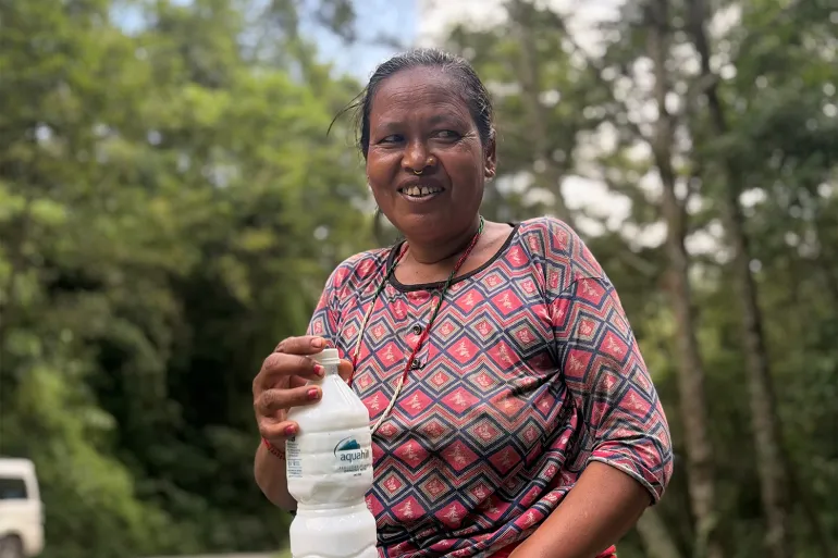 Holding a bottle of buttermilk, Seeta Nepali waits for the tourists to arrive