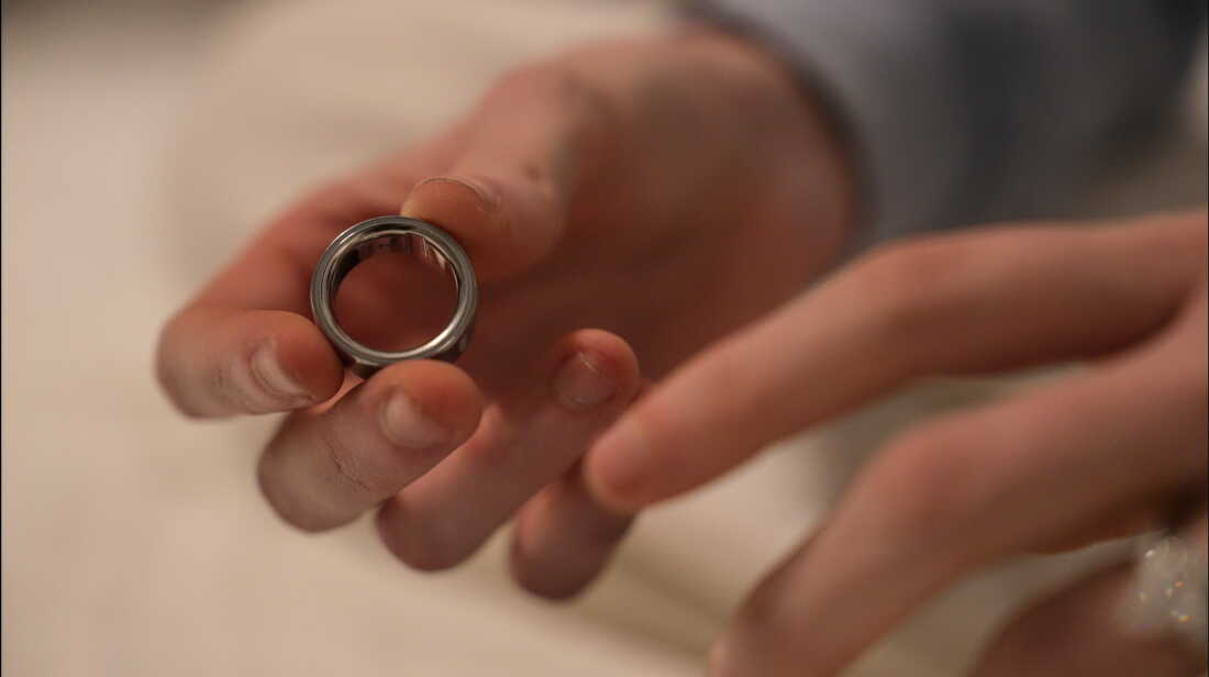 A woman puts on an Oura ring, a wearable health tracking device, whose maker is slated to go public in one of this year's blockbuster IPOs. 