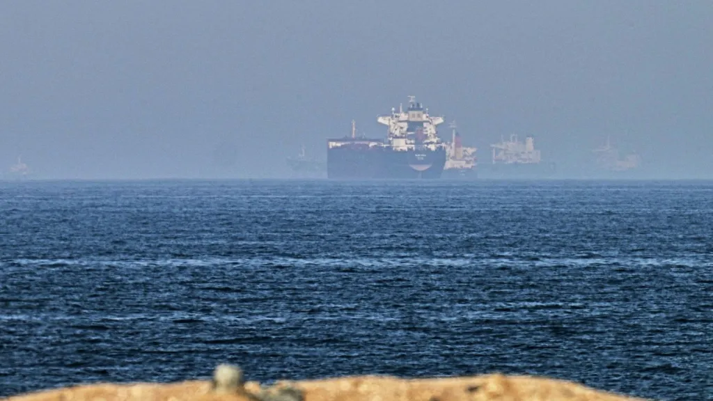 Cargo ships are seen at sea near the Strait of Hormuz, as viewed from a rocky shoreline near Khor Fakkan, United Arab Emirates (AP Photo)