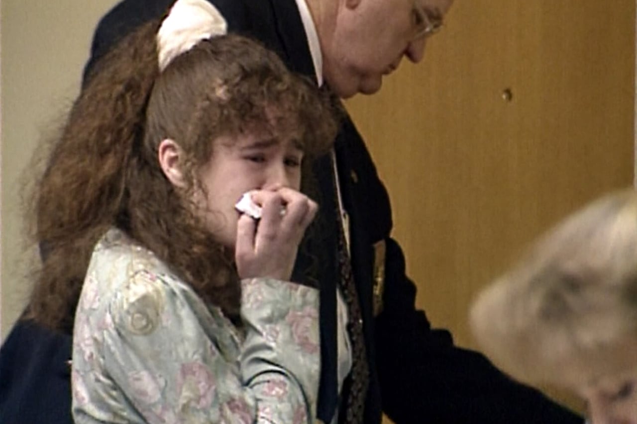 A woman cries in a courtroom.
