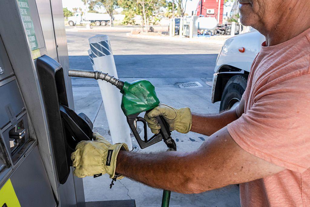 A driver returns a fuel nozzle after refueling a tractor trailer with diesel fuel at a Chevron truck stop in Tracy, California. 