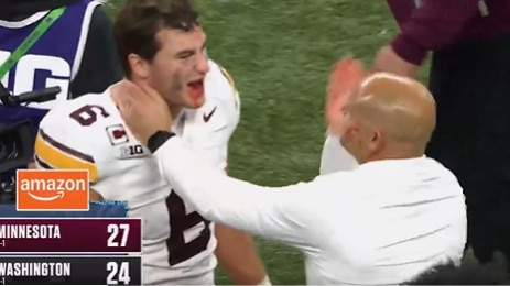 A screenshot of a video of a coach wiping a player's blood on his face.