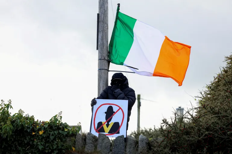 A demonstrator holds a placard, as people protest on the Garvaghy Road, a Catholic enclave in the largely Protestant town of Portadown, against the Protestant Orange Order's annual Drumcree parade, in Northern Ireland, September 27, 2026. REUTERS/Cathal McNaughton TPX IMAGES OF THE DAY