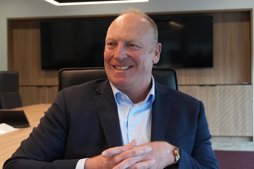 CDC Data Centres founder and Chief Executive Greg Boorer sitting in a chair in a board room, smiling