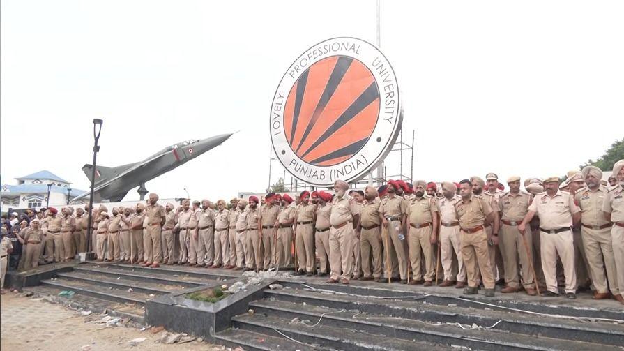 Dozens of policemen standing near the signage of the university 