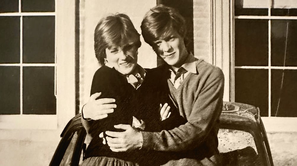 A young man and woman hug in a sepia photo
