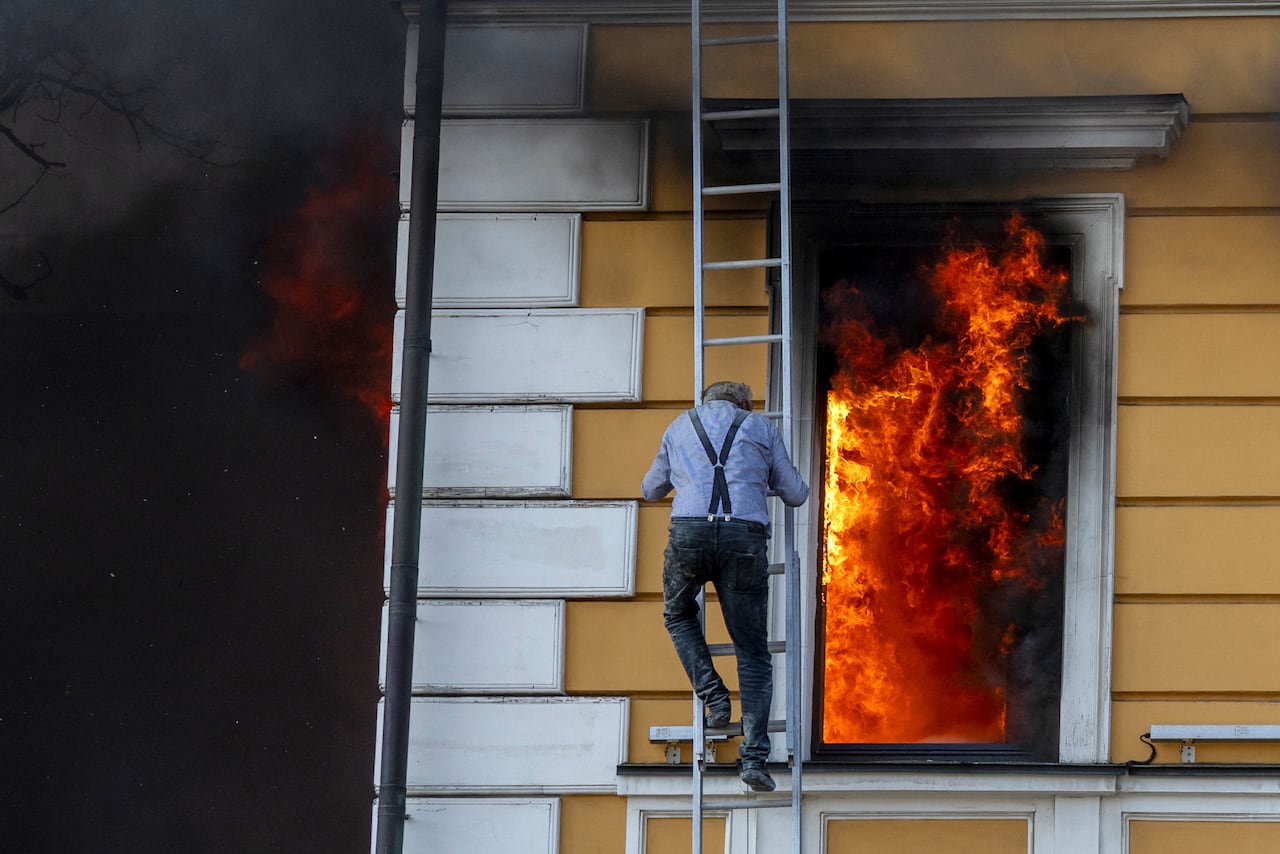 A man escapes from an administrative building in Kyiv which caught fire after being hit by a Russian jet-powered drone.