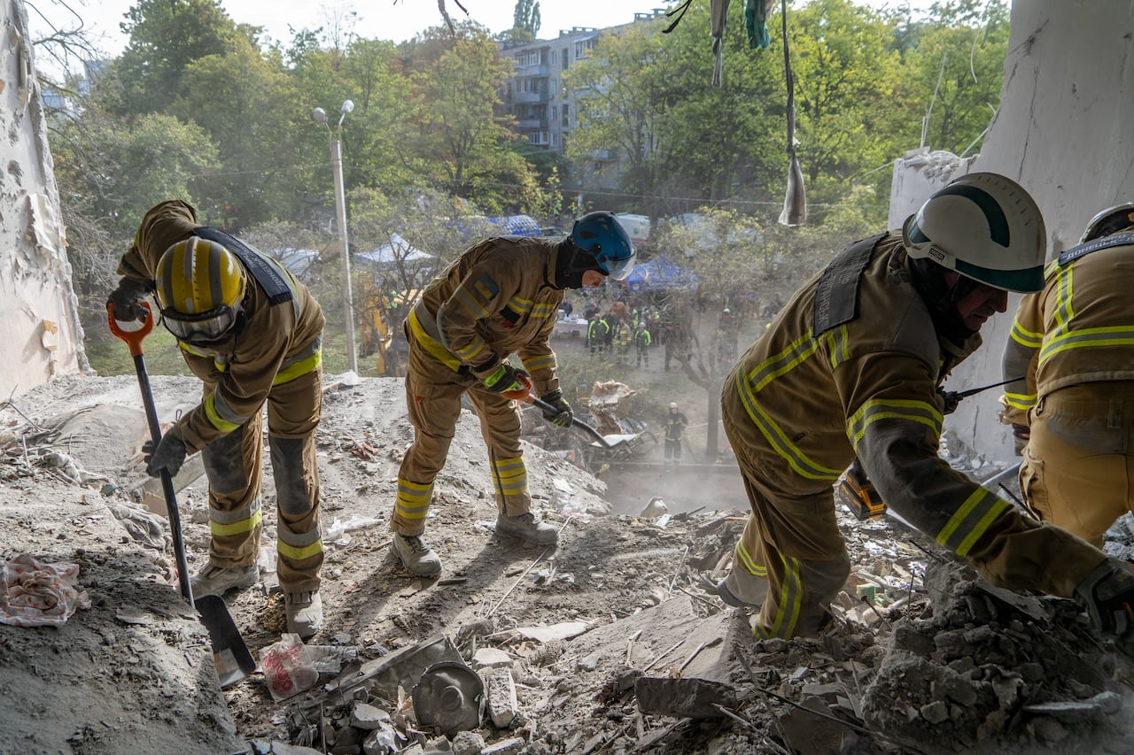 Rescue workers clear rubbles from a home damaged by a Russian strike in Kharkiv, Ukraine.
