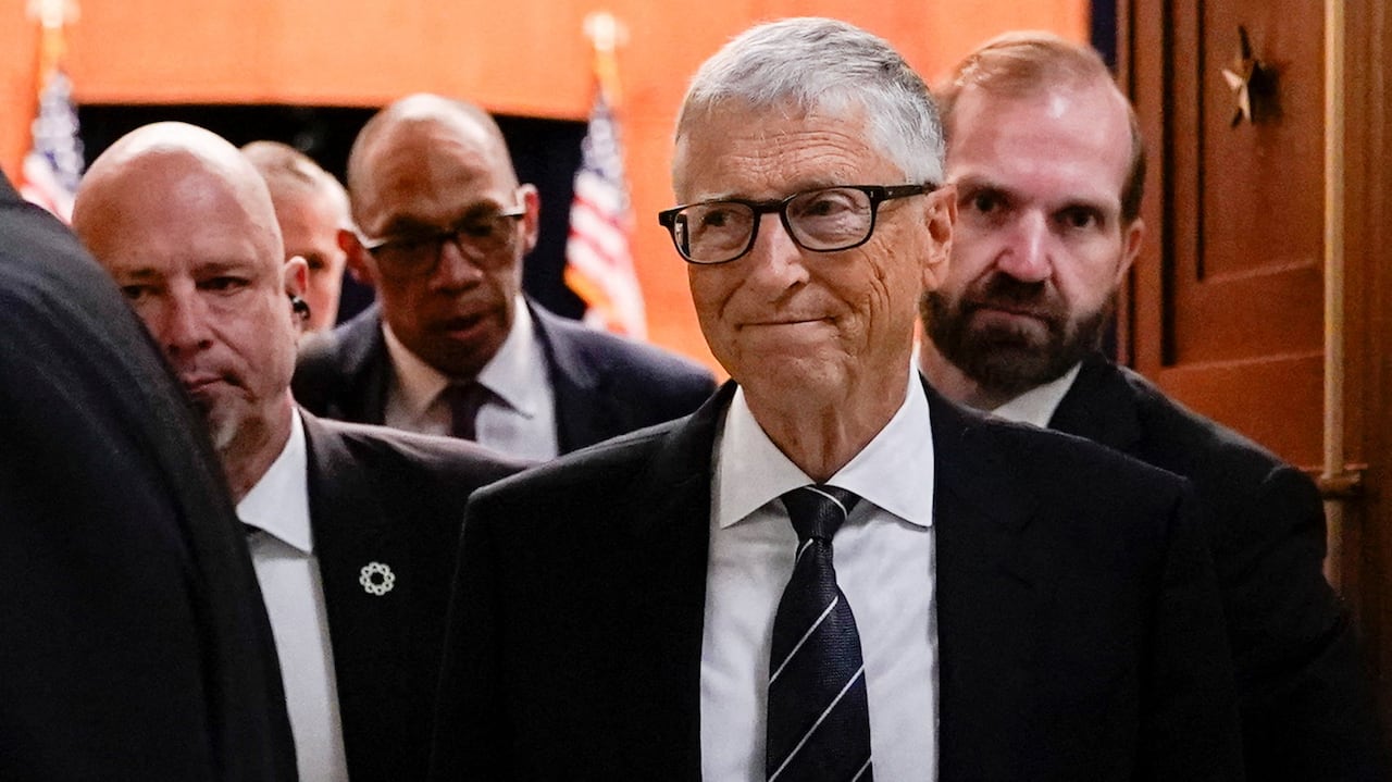 Bill gates surrounded by other people in suits