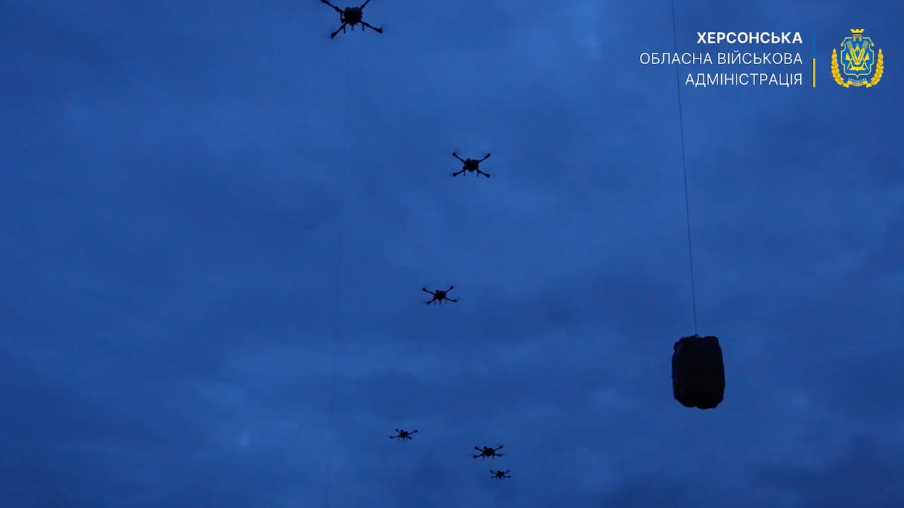 Drones in the night sky carry packages.