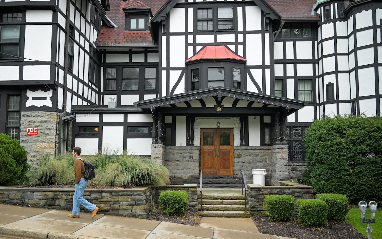 A person walks past a large house
