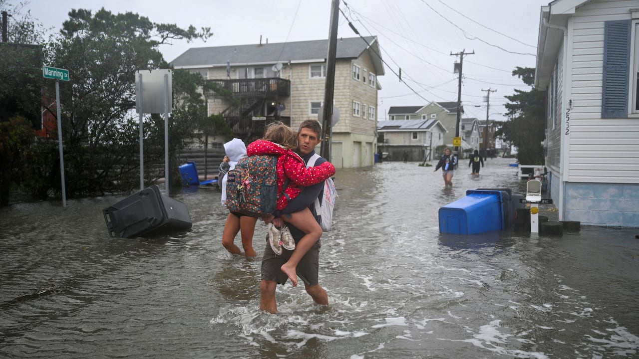 People wade through a flooded street.