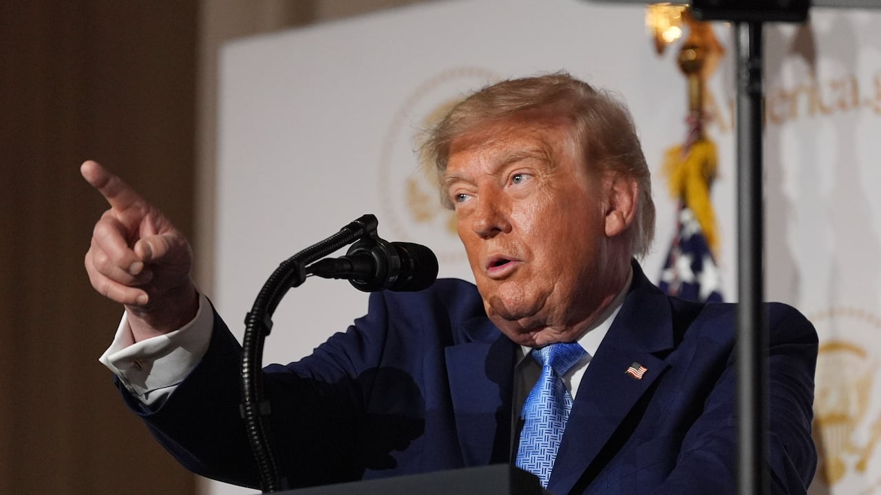 U.S. President Donald Trump gestures from behind a podium.