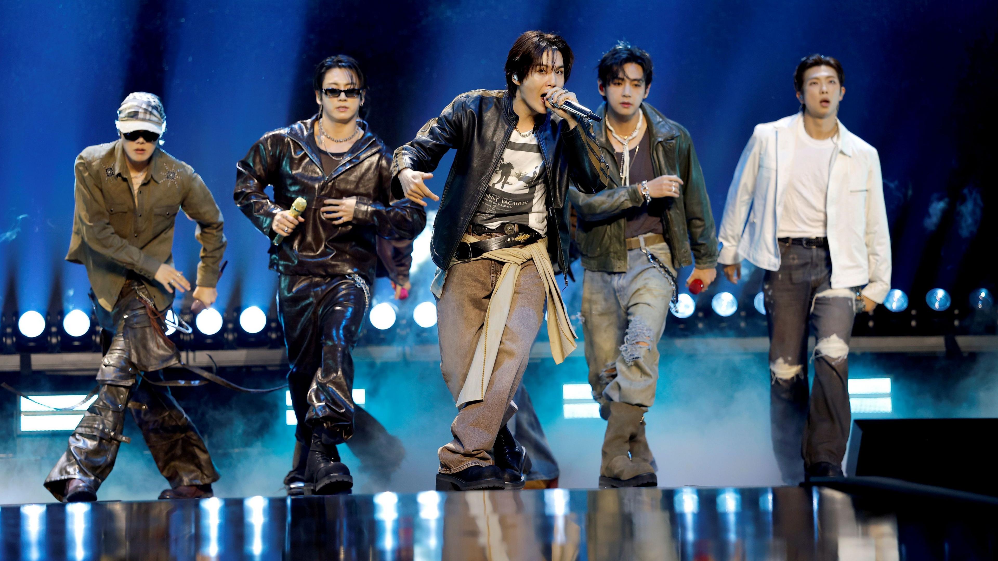 Five members of K-Pop group BTS perform on stage. 