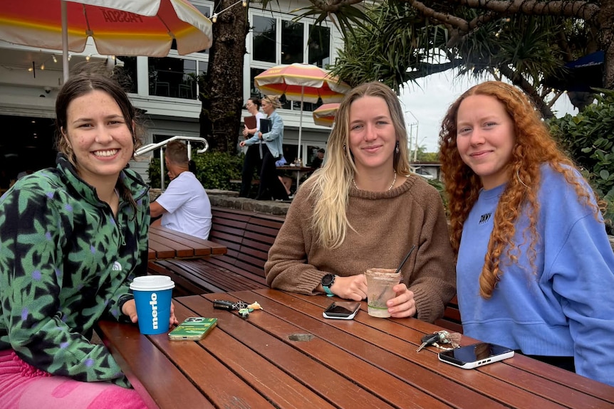 Girls sitting around a table smiling with coffees