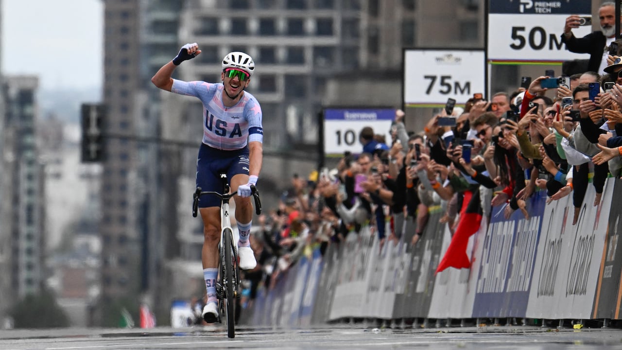 A men's cyclist crosses the finish line.